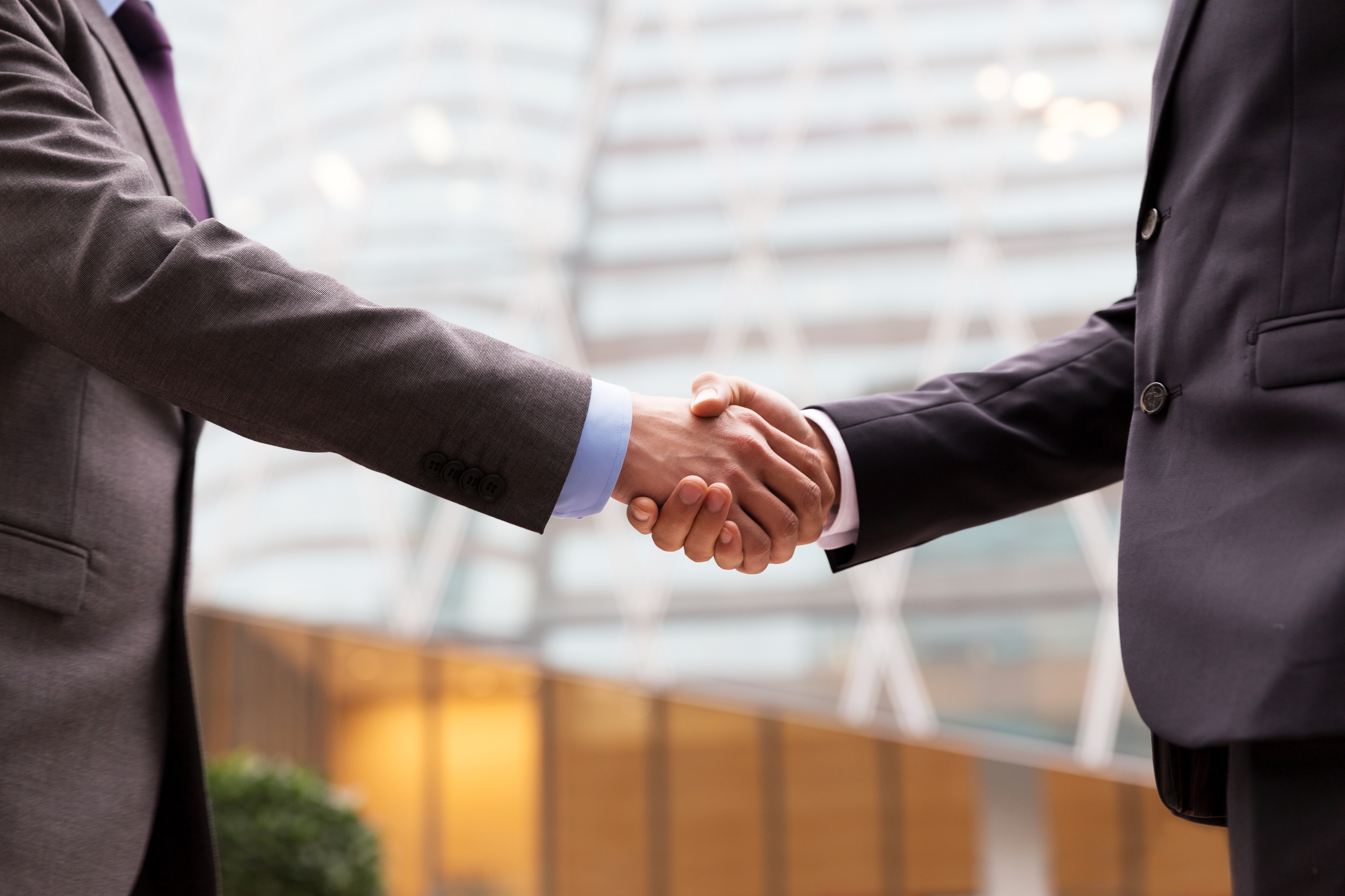 企業の事業承継・M&Aで握手を交わすビジネスパートナー - リブメーカーズの事業承継支援
